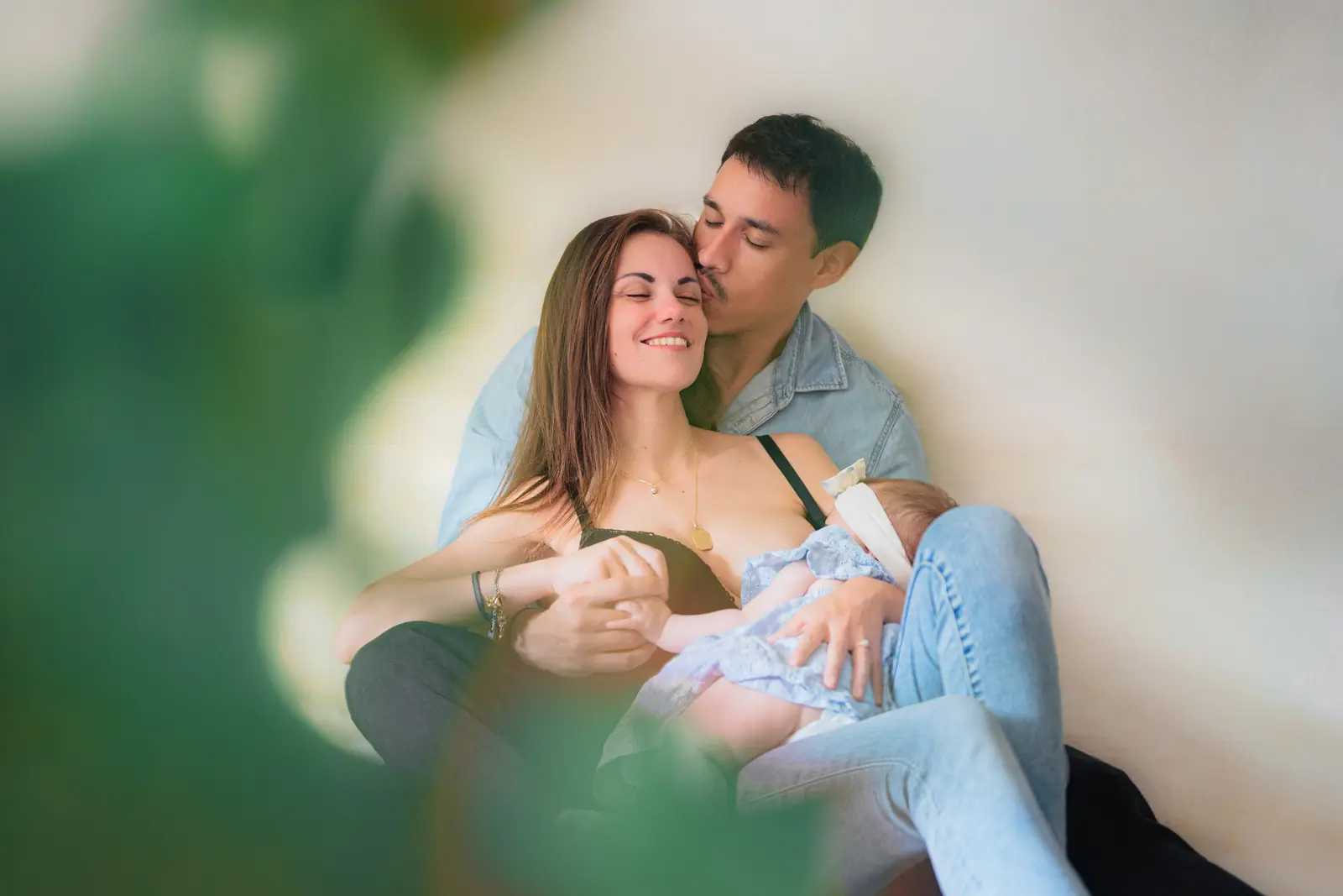 Parents on the floor of their living room holding their newborn