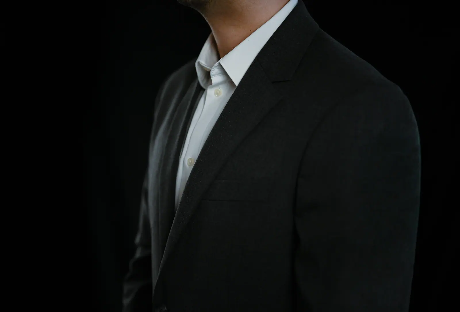 Dark suit jacket over a white shirt, close crop